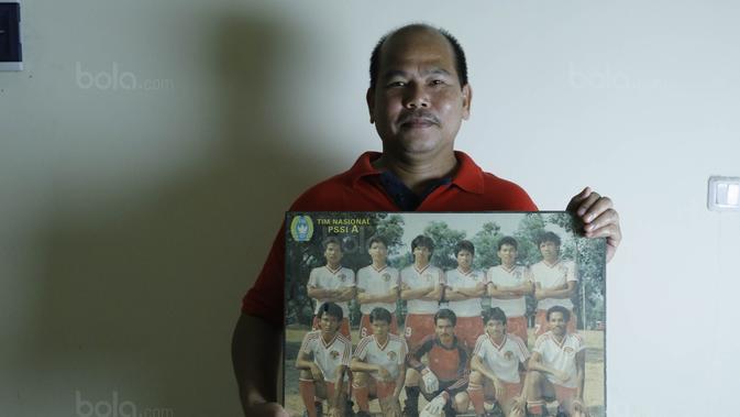 Mantan gelandang Timnas Indonesia, Patar Tambunan, memegang foto Timnas Indonesia saat ditemui di kawasan Bintaro, Selasa (01/8/2017). Patar Tambunan adalah salah satu pemain yang mengantarkan Indonesia menjadi juara di Sea Games 1987. (Bola.com/M Iqbal I