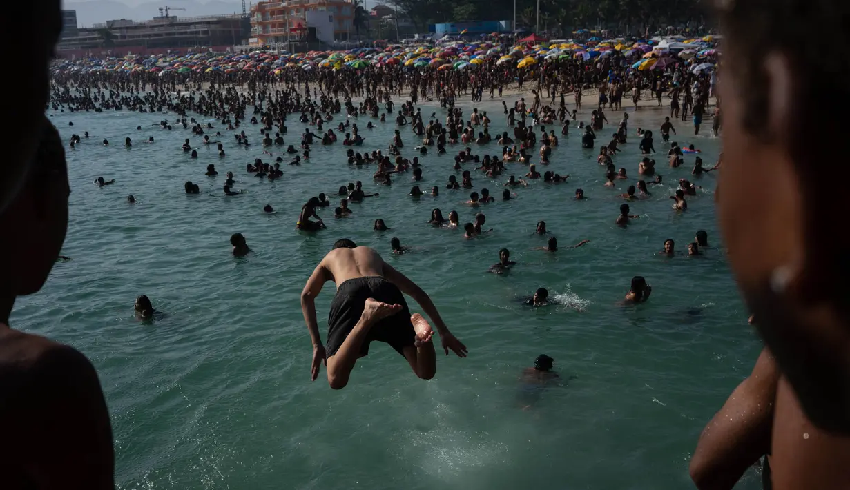 Anak-anak melompat untuk berenang di pantai Macumba. (Tercio Teixeira/AFP)