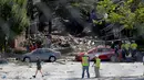 Pemadam kebakaran mengamati puing bangunan apartemen di Sivler Spring, Maryland, Washington DC, Kamis (11/8). Sedikitnya 2 orang tewas dan tujuh lainnya hilang setelah ledakan gas alam yang menyebabkan kebakaran di apartemen itu. (REUTERS/Joshua Roberts)