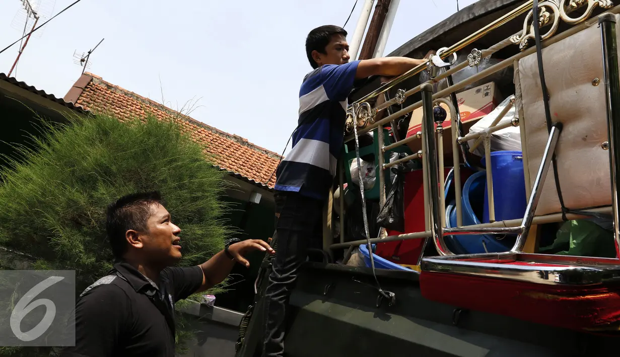 Warga memasukan barang-barang ke dalam mobil truk TNI usai dilakukan pengosongan oleh Komando Daerah Militer Jayakarta (Kodam Jaya), Jakarta, Kamis (3/9/2015). Sebanyak 99 rumah dikosongkan oleh Kodam Jaya. (Liputan6.com/Yoppy Renato)