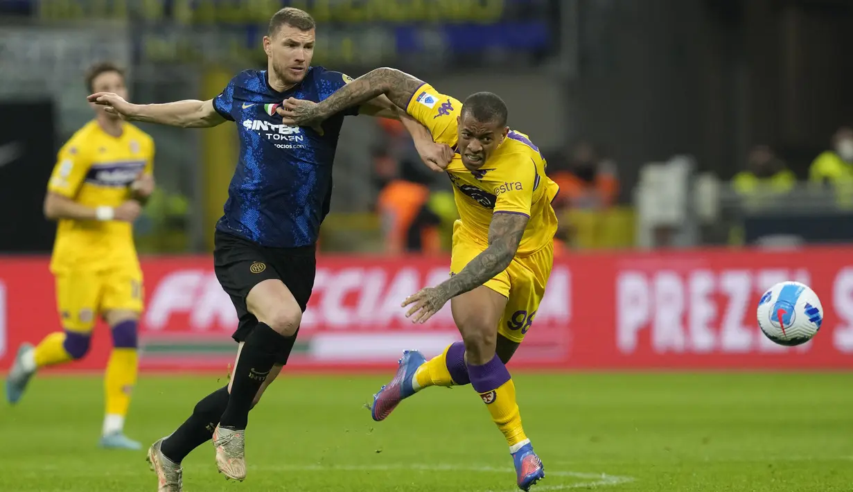 Penyerang Inter Milan, Edin Dzeko berebut bola dengan pemain Fiorentina Igor pada pertandingan lanjutan Liga Serie A Italia di Stadion San Siro, di Milan, Italia, Minggu (20/3/2022). Inter Milan bermain imbang atas Fiorentina 1-1. (AP Photo/Antonio Calanni)