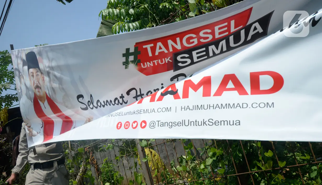 Petugas Satpol PP menertibkan Alat Peraga Kampanye (APK) bakal calon Wali Kota dan Wakil Wali Kota Tangerang Selatan di sepanjang jalan raya di Kota Tangerang Selatan, Kamis (27/8/2020). Semua poster dan baliho diturunkan karena tidak memiliki izin dan masa izin telah habis. (merdeka.com/Dwi Narwoko