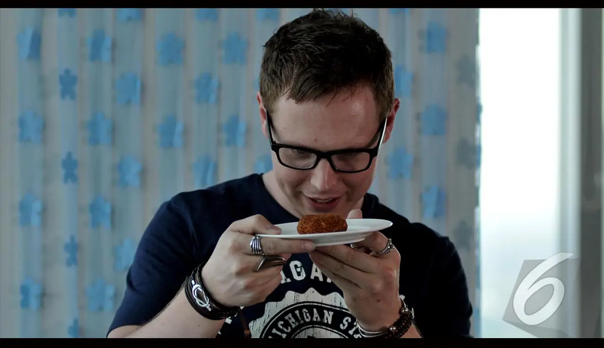 Matt Hart memperhatikan dengan seksama kue ketan yang akan dimakannya. Foto diambil pada Rabu (17/8/2014) (Liputan6.com/Johan Tallo)