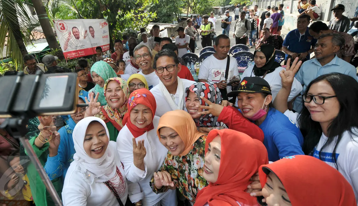 Sejumlah warga berselfie dengan Calon Wakil Gubernur DKI Jakarta, Sandiaga Salahudin Uno, Jakarta, Selasa (6/12). Selain meminta doa restu, Sandiaga Uno juga mensosialisasikan visi dan misinya bila terpilih nanti. (Liputan6.com/Yoppy Renato)