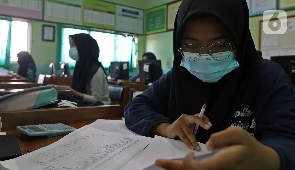 Siswi SMK PB Soedirman jurusan akuntansi melakukan persiapan Uji Sertifikasi Kompetensi (USK) bagi para siswa kelas XII di SMK PB Soedirman, Jakarta, Selasa (6/4/2021). USK dilakukan di tengah pandemi COVID-19. (Liputan6.com/Herman Zakharia)