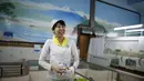 Mizuki Tanaka tersenyum usai menyelesaiakan lukisannya di salah satu pemandian umum, Tokyo,Jepang,  Senin (5/10/2015). Ia merupakan seorang pelukis "sento" atau pemandian air panas untuk umum di Jepang. (REUTERS/Issei Kato)