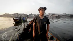 Supardi ditemani oleh ayahnya menuju lokasi Kerang Hijau di kawasan pesisir Cilincing, Jakarta, Jumat (17/6). Supardi mengaku sudah berkeluarga dan mempunyai 2 orang anak. (Liputan6.com/Faizal Fanani)