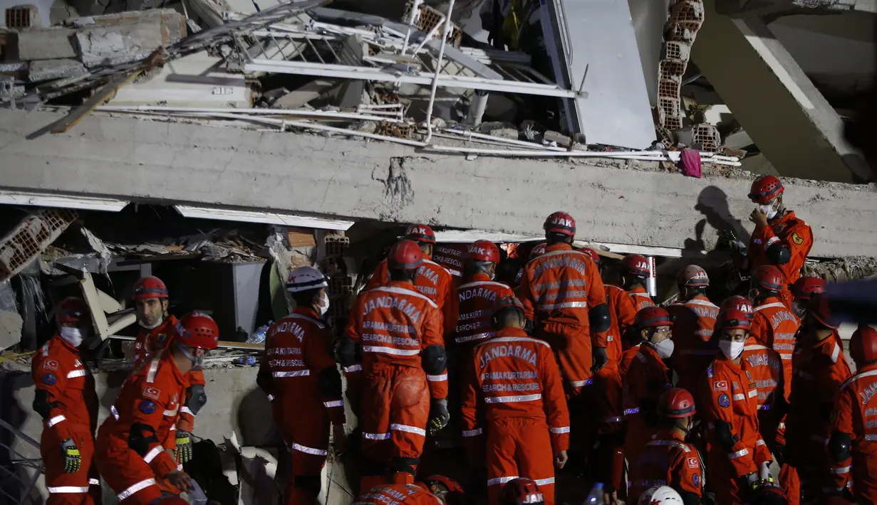 Anggota layanan penyelamatan mencari orang-orang yang selamat di puing-puing bangunan yang runtuh di Izmir, Turki, Sabtu (31/10/2020). Gempa bumi yang kuat melanda pada hari Jumat di Laut Aegea antara pantai Turki dan pulau Samos di Yunani, menewaskan beberapa orang. (AP Photo/Emrah Gurel)