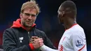 Pelatih Liverpool, Jurgen Klopp (kiri) memberikan ucapan kepada Christian Benteke usai menang atas Crystal Palace pada lanjutan liga Inggris 2015-2016 di Stadion Selhurts Park, Minggu (6/3/2016) malam WIB. (AFP/Glyn Kirk)