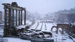 Bangunan kuno yang tertutup salju tebal di Roma, Italia (26/2). Badai salju yang melanda Italia menganggu transportasi dan sekolah diliburkan. (AFP Photo/Vicenzo Pinto)
