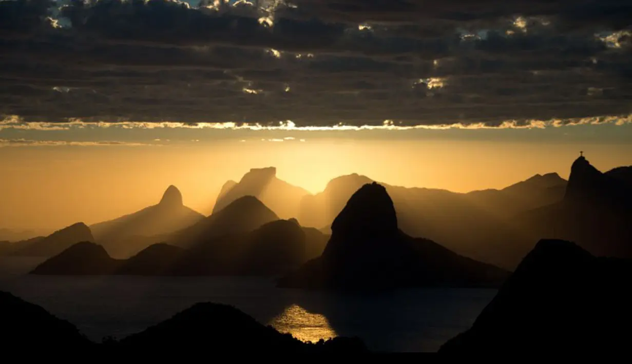 Matahari terbenam di atas Rio de Janeiro dilihat dari Niteroi, Brasil (AFP PHOTO/Christophe Simon)
