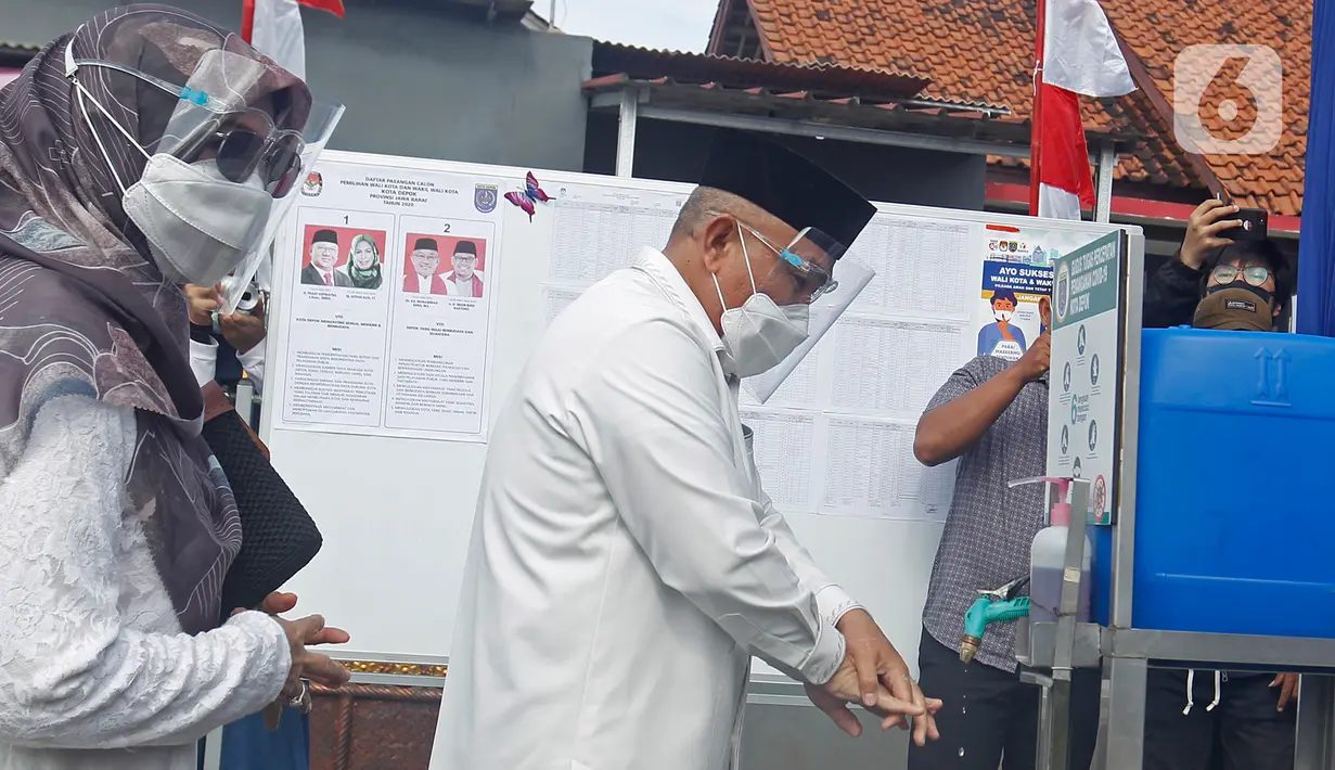 Calon Wali Kota Depok nomor urut 2 Mohammad Idris mencuci tangan sebelum menggunakan hak pilihnya pada Pilkada 2020 di TPS 14 Jatimulya, Depok, Rabu (9/12/2020). Pilkada Depok 2020 diikuti oleh Pradi Supratna-Afifah Alia serta Mohammad Idris dan Imam Budi Hartono. (Liputan6.com/Herman Zakharia)