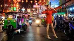 Seorang wanita berpose untuk berfoto di jalan yang didekorasi untuk menyambut Tahun Baru Imlek yang akan datang di Chinatown Bangkok (9/2/2021). Perayaan Tahun Baru Imlek 2021 di Chinatown Yaowarat Bangkok secara resmi dibatalkan menurut Administrator Metropolitan Bangkok. (AFP/ Mladen Antonov)