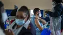 Orang-orang mendapatkan vaksinasi COVID-19 di rumah sakit Baragwanath Soweto, Senin (13/12/2021). Afrika Selatan memiliki 7,60 kasus baru per 100.000 orang pada 28 November, naik menjadi 32,71 kasus baru per 100.000 orang pada 12 Desember, menurut Universitas Johns Hopkins. (AP Photo/Jerome Delay)