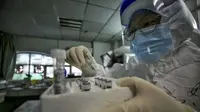 File foto yang diambil pada 10 Maret 2020 menunjukkan seorang anggota staf medis memegang sampel dari pasien yang terinfeksi oleh Virus Corona baru sebelum tes asam nukleat di Rumah Sakit Palang Merah di Wuhan di provinsi Hubei tengah China. (STR / AFP)