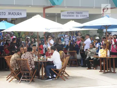 Presiden Joko Widodo (Jokowi) berbincang sambil menjajal makanan saat meninjau Rest Area 538 seusai meresmikan ruas  Tol Sragen-Ngawi, Jawa Tengah, Rabu (28/11). Jokowi duduk semeja dengan kepala serta pimpinan daerah setempat. (Liputan6.com/Angga Yuniar)