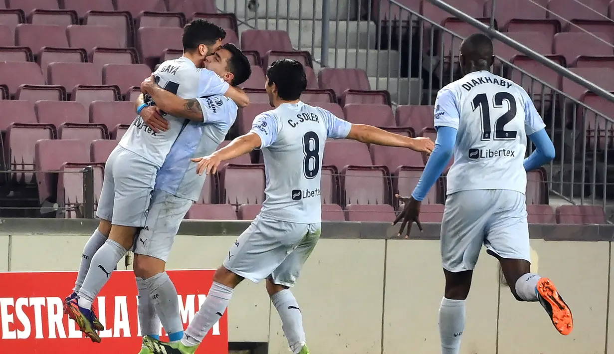 Para pemain Valencia merayakan gol penyeimbang 2-2 yang dicetak striker Maxi Gomez (kedua dari kiri) ke gawang Barcelona dalam laga lanjutan Liga Spanyol 2020/21 di Camp Nou Stadium, Barcelona, Sabtu (19/12/2020). Valencia bermain imbang 2-2 dengan Barcelona. (AFP/Lluis Gene)