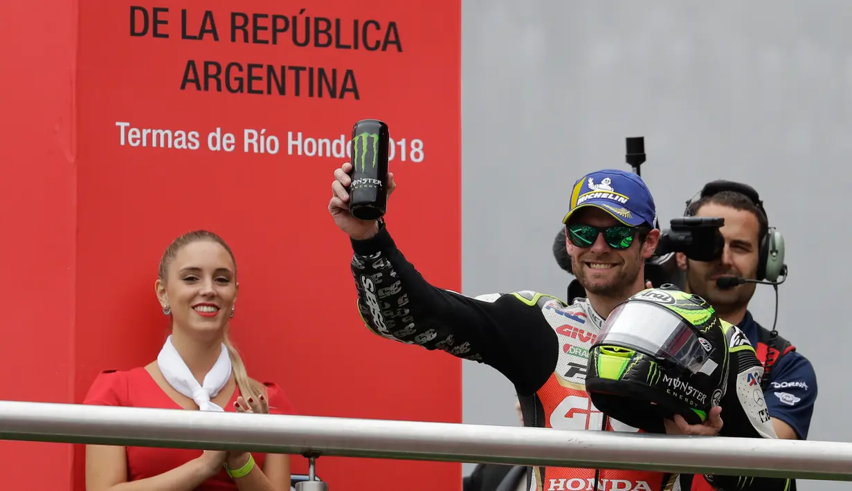 Pembalap LCR Honda, Cal Crutchlow merayakan kemenangannya pada balapan MotoGP Argentina di atas podium Sirkuit Termas de Rio Hondo, Minggu (8/4). Kemenangan ini menempatkan Crutchlow di puncak klasemen sementara dengan poin 38. (AP/Natacha Pisarenko)