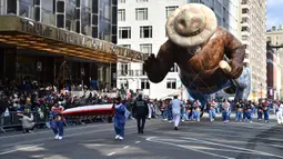 Peserta menerbangkan balon  bernama Smokey the Bear dalam parade perayaan Hari Thanksgiving di kawasan Sixth Avenue, New York, Kamis (28/11/2019). Parade yang membelah jalanan kota New York ini selalu ditunggu setiap tahunnya. (Theo Wargo/Getty Images/AFP)