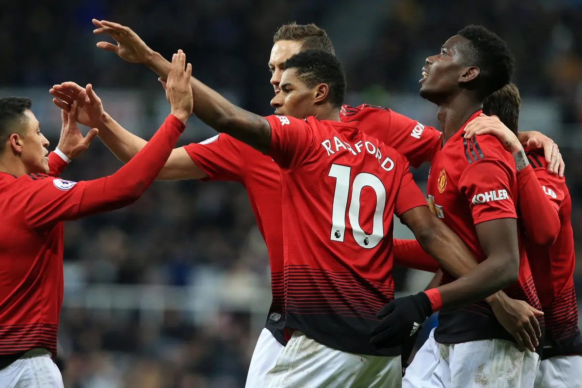 Para pemain Manchester United merayakan gol yang dicetak Marcus Rashford ke gawang Newcastle pada laga Premier League di Stadion St James Park, Newcastle, Rabu (2/1). Newcastle kalah 0-2 dari MU. (AFP/Lindsey Parnaby)