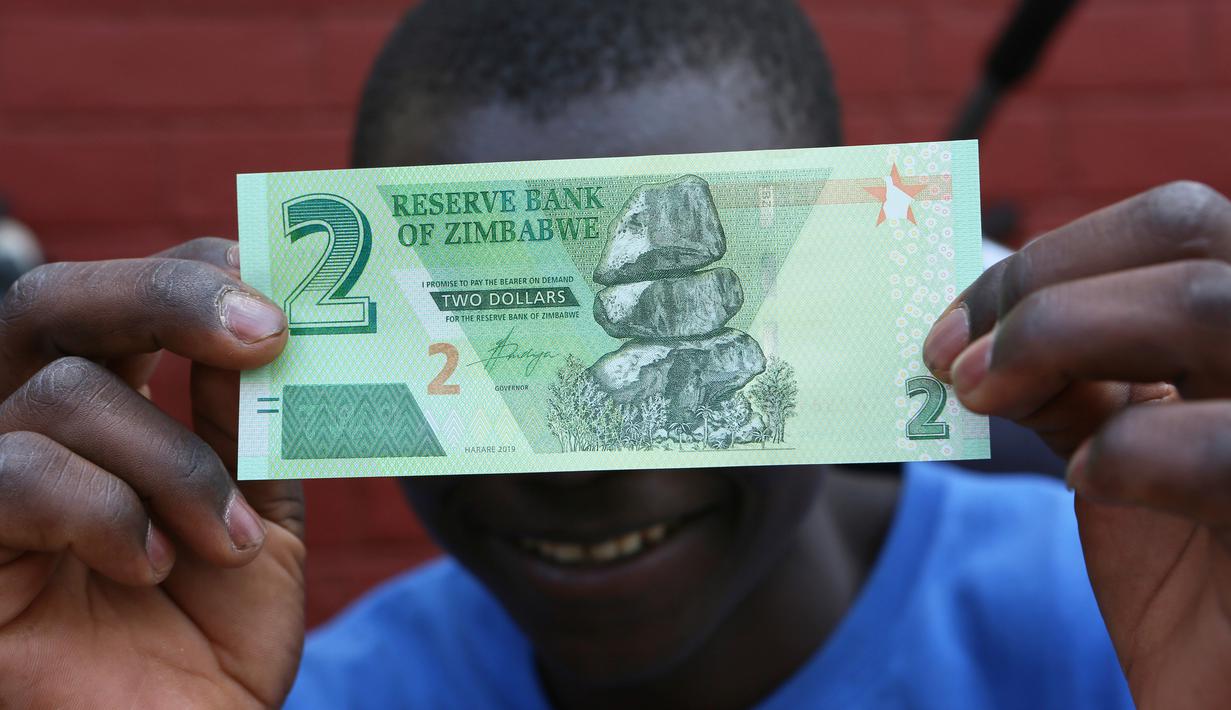 Seorang warga memegang salah satu uang kertas baru yang dikeluarkan Reserve Bank of Zimbabwe di Harare, 12 November 2019. Pemerintah Zimbabwe memperkenalkan kembali mata uang negaranya setelah hampir satu dekade terakhir menggunakan mata uang negara lain untuk bertransaksi. (AP/Tsvangirayi Mukwazhi)