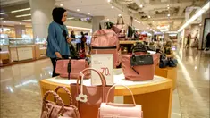Seorang wanita melihat tas yang dijual di salah satu tenant di Lotte Mall, Jakarta, Kamis (13/4/2023). (Liputan6.com/Faizal Fanani)