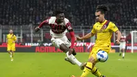 Penyerang AC Milan, Rafael Leao menembak bola dari kawalan pemain Bologna, Arthur Theate pada pertandingan Liga Serie A Italia di stadion San Siro, Italia (5/4/2022). AC Milan bermain imbang atas Bologna 0-0. (AP Photo/Antonio Calanni)