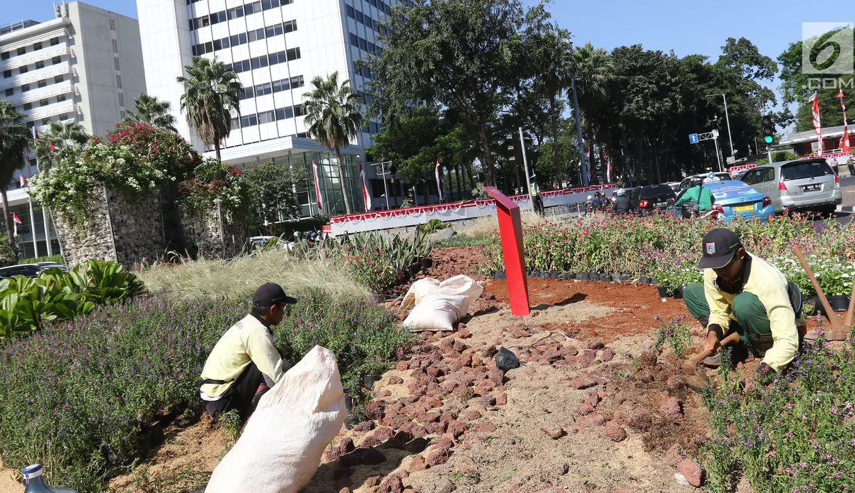 Petugas Dinas Kehutanan DKI Jakarta menanam bunga bougenville amenities di kawasan Bundaran HI, Jakarta, Rabu (21/8/2019). Pemprov DKI Jakarta melakukan penanaman bougenville amenities di sepanjang Jalan Sudirman-Jalan MH Thamrin guna mengendalikan kualitas udara. (Liputan6.com/Herman Zakharia)