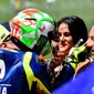 Pembalap Movistar Yamaha, Valentino Rossi menghampiri kekasihnya, Francesca Sofia Novello usai merebut pole position kualifikasi MotoGP Italia 2018. (TIZIANA FABI / AFP)