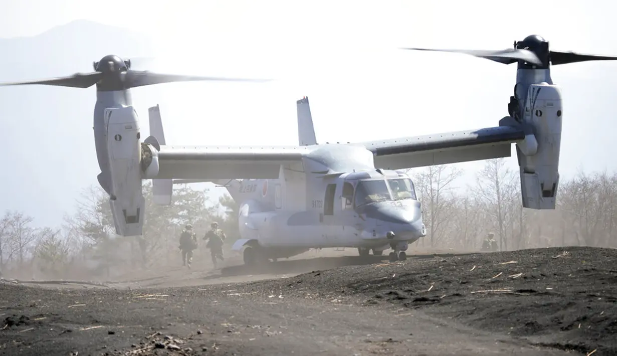 Anggota Pasukan Bela Diri Darat Jepang (JGSDF) bergegas keluar dari osprey V-22 saat mereka mengambil bagian dalam latihan operasi gabungan helikopter militer antara Pasukan Bela Diri Darat Jepang (JGSDF) dan Marinir AS di Higashi Fuji, Gotemba, Jepang, Selasa (15/3/2022). (AP Photo/Eugene Hoshiko)
