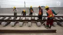 Pekerja memasang rel di Depo LRT, Kelapa Gading, Jakarta Utara, Kamis (25/1). Rencananya, LRT akan mulai diuji coba pada Mei mendatang. (Liputan6.com/Arya Manggala)