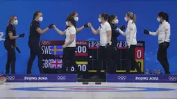 Tim Swedia (berbaju biru) dan Inggris saling menyapa sebelum dimulainya pertandingan semifinal curling putri antara Inggris dan Swedia di Olimpiade Musim Dingin Beijing di Beijing, Jumat (18/2/2022).  (AP Photo/Nariman El-Mofty)