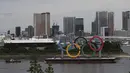 Sebuah perahu menarik cincin Olimpiade raksasa saat dipindahkan dari area tepi laut di Taman Laut Odaiba setelah Olimpiade Musim Panas 2020 berakhir pada 8 Agustus di Tokyo, Rabu (11/8/2021). Ajang yang digelar sejak 23 Juli itu memastikan Kontingen AS menjadi juara umum (Kim Kyung-Hoon/Pool via AP)