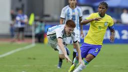 Pemain Timnas Argentina U-23, Valentin Barco (kiri) terjatuh usai perebutan bola dengan pemain Brasil U-23, Andrey Santos pada laga Kualifikasi Olimpiade Paris 2024 Zona Conmebol di Brigido Iriarte Stadium, Caracas, Venezuela, Minggu (11/2/2024). (AP Photo/Matias Delacroix)
