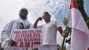 Peserta membawa poster dan bendera merah putih serta mengenakan baju pejuang yang menyerupai tokoh pahlawan saat memperingati Hari Pahlawan di Lapangan Simpanglima, Semarang, Kamis (10/11). (Liputan6.com/Gholib) 
