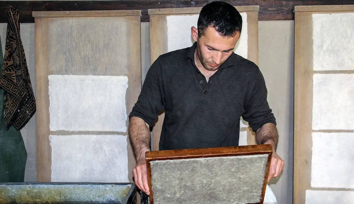 Seorang pria membuat kertas secara tradisional di pabrik kertas Zarif Mukhtarov di desa Koni Ghil, Uzbekistan (29/3). Pabrik kertas Zarif Mukhtarov ini milik seorang pria bernama Samarkand yang berusia 62 tahun. (STR/AFP)