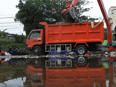Petugas mengangkut sampah yang terbawa arus sungai Ciliwung ke dalam truk, Jakarta, Selasa (23/10). Dinas Lingkungan Hidup mengantisipasi terjadinya peningkatan volume sampah saat musim penghujan tiba di setiap pintu air Jakarta. (Merdeka.com/Imam Buhori)