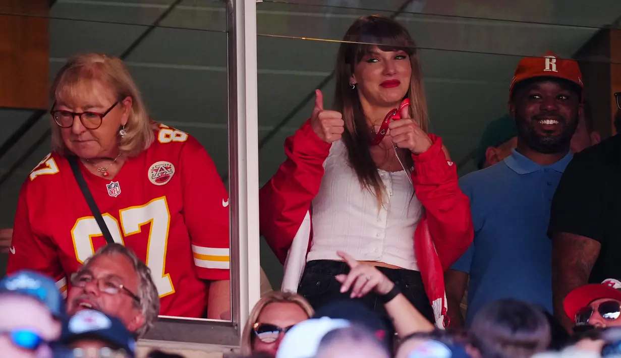 Penyanyi Amerika Serikat, Taylor Swift (tengah) memberikan gestur dua jempol di samping ibunda Travis Kelce, Donna Kelce saat menonton laga National Football League (NFL) antara Kansas City Chiefs melawan Chicago Bears di Arrowhead Stadium, Kansas, Misouri, Amerika Serikat pada Minggu (24/09/2023) waktu setempat. (AFP/Getty Images/Jason Hanna)