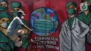 Pesepeda melintas di depan mural tentang pandemi virus COVID-19 di Jalan Raya Jakarta-Bogor, Depok, Selasa (7/4/2020). Mural tersebut ditujukan sebagai bentuk dukungan kepada tenaga medis yang menjadi garda terdepan menghadapi COVID-19 di Indonesia. (Liputan6.com/Helmi Fithriansyah)