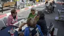 Orang-orang makan di restoran setelah pembatasan virus corona dilonggarkan di Tel Aviv, Minggu (7/3/2021). Israel membuka kembali sebagian besar ekonominya sebagai bagian dari fase terakhir pencabutan kebijakan lockdown yang berlaku sejak September tahun lalu. (AP Photo/Ariel Schalit)