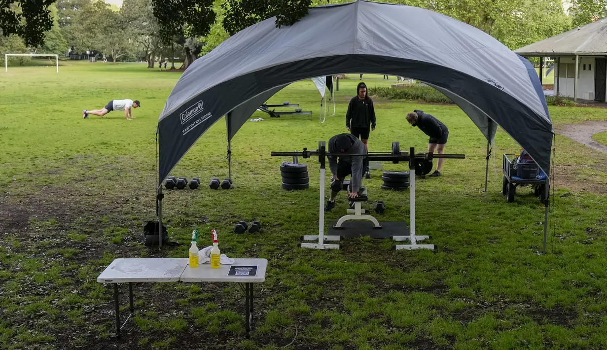 Orang-orang berolahraga di sebuah taman di pinggiran timur Sydney, pada 14 September 2021. Pelatih pribadi telah mengubah taman kawasan tepi laut di Rushcutters Bay Sydney menjadi gym luar ruangan untuk menyiasati pembatasan lockdown karena pandemi covid-19. (AP/Mark Baker)