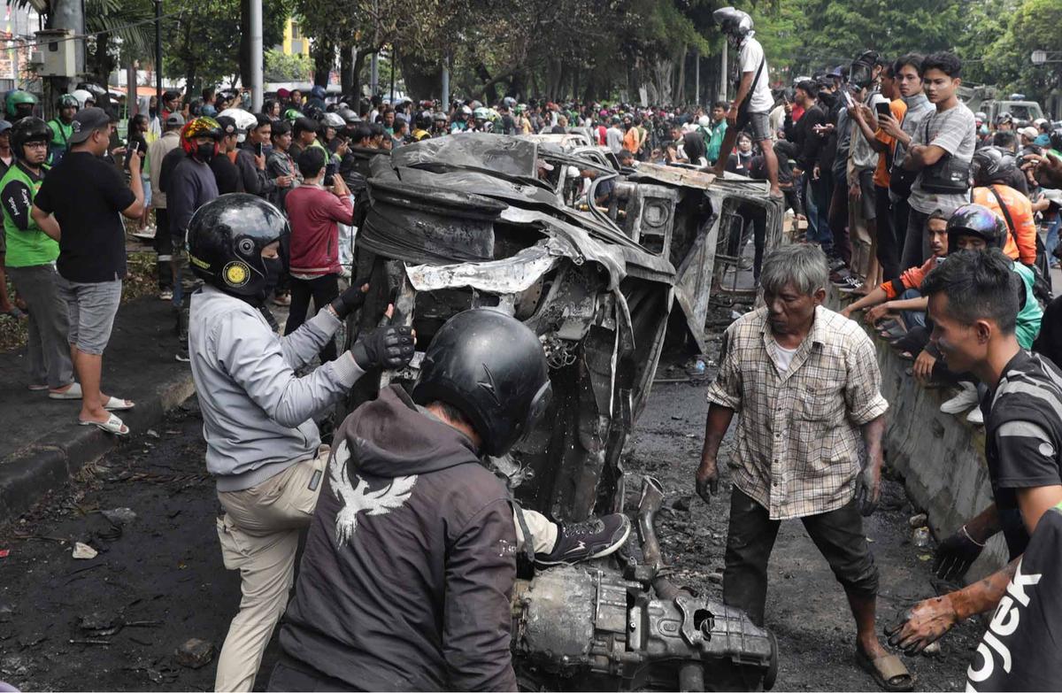 FOTO: Warga Ambil Bangkai Mobil Usai 10 Kendaraan Dibakar di Depan Mako Brimob Kwitang