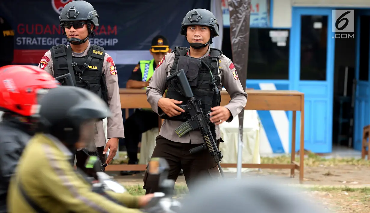 Dua polisi bersenjata laras panjang bersiaga di jalur pantura Jalan Jenderal Ahmad Yani, Bypass, Kota Cirebon, Kamis (22/6). Selama arus mudik Lebaran, pasukan bersenjata lengkap diterjunkan guna mengantisipasi gangguan keamanan (Liputan6.com/Johan Tallo)