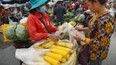 Seorang wanita membeli jagung rebus di sebuah pasar di Phnom Penh (24/7/2020). Pasar membentuk bagian integral dalam kehidupan orang Kamboja, dengan kunjungan harian yang dilakukan untuk persediaan makanan untuk hari itu serta barang-barang lainnya. (AFP/Tang Chhin Sothy)