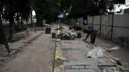 Pekerja Dinas SDA menyelesaikan proyek revitalisasi trotoar di Jalan RM Margono Djojohadikoesoemo, Jakarta, Kamis (16/1/2020). Trotoar di sisi selatan Kanal Banjir Barat itu akan dilengkapi taman dan deck view untuk melihat pemandangan Kali Ciliwung dan gedung perkantoran (merdeka.com/Iqbal Nugroho)