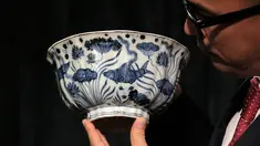  Pekerja memegang sebuah mangkuk Xuande Lobel "Fish Pond" saat ditampilkan di pelelangan Sotheby di Hong Kong (8/3). Mangkuk ini diperkirakan akan terjual dengan harga lebih dari USD 12,8 juta atau sekitar Rp 171 miliar. (AP Photo / Kin Cheung)