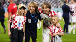 Gelandang Kroasia, Luka Modric berfoto bersama anak-anaknya Sofia, Ivano, dan Ema setelah kemenangan melawan Maroko pada pertandingan playoff perebutan peringkat ketiga Piala Dunia 2022 di Khalifa International Stadium di Doha, Qatar, Sabtu (17/12/2022). Modric punya 161 caps serta menyumbang 23 gol dan 25 assist bagi tim berjuluk Vatreni itu. (AP Photo/Hassan Ammar)
