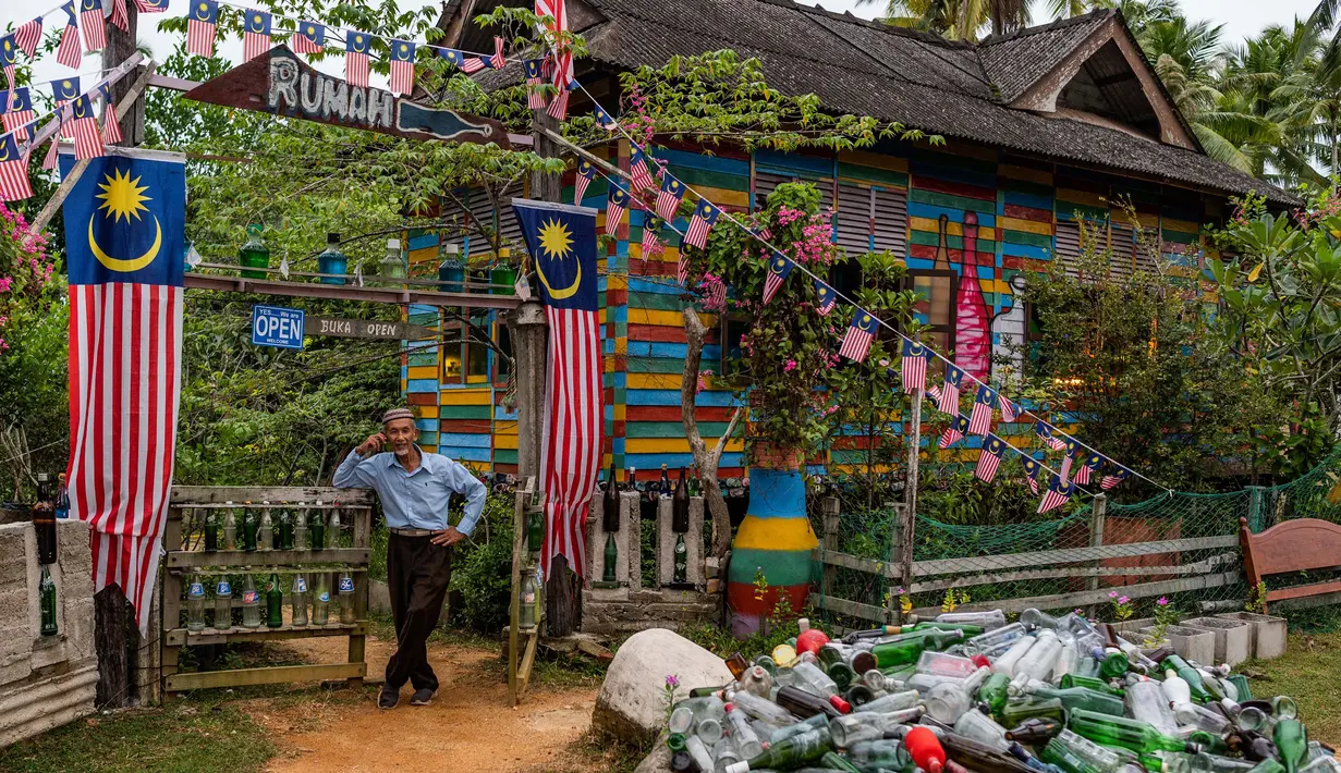 Tengku Mohamad Ali Mansor berpose di luar museum botolnya di desa Penarik di distrik Setiu, negara bagian Terengganu, Malaysia timur pada 11 September 2020.  (AFP/Mohd Rasfan)