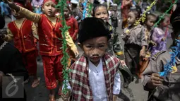 Murid-murid TK Sekolah Alternatif untuk Anak Jalanan (SAAJA) saat pawai sambil mengenakan pakaian adat di kawasan Kuningan, Jakarta, Kamis (21/4). Kegiatan ini dalam rangka memperingati Hari Kartini yang jatuh pada 21 April. (Liputan6.com/Faizal Fanani)