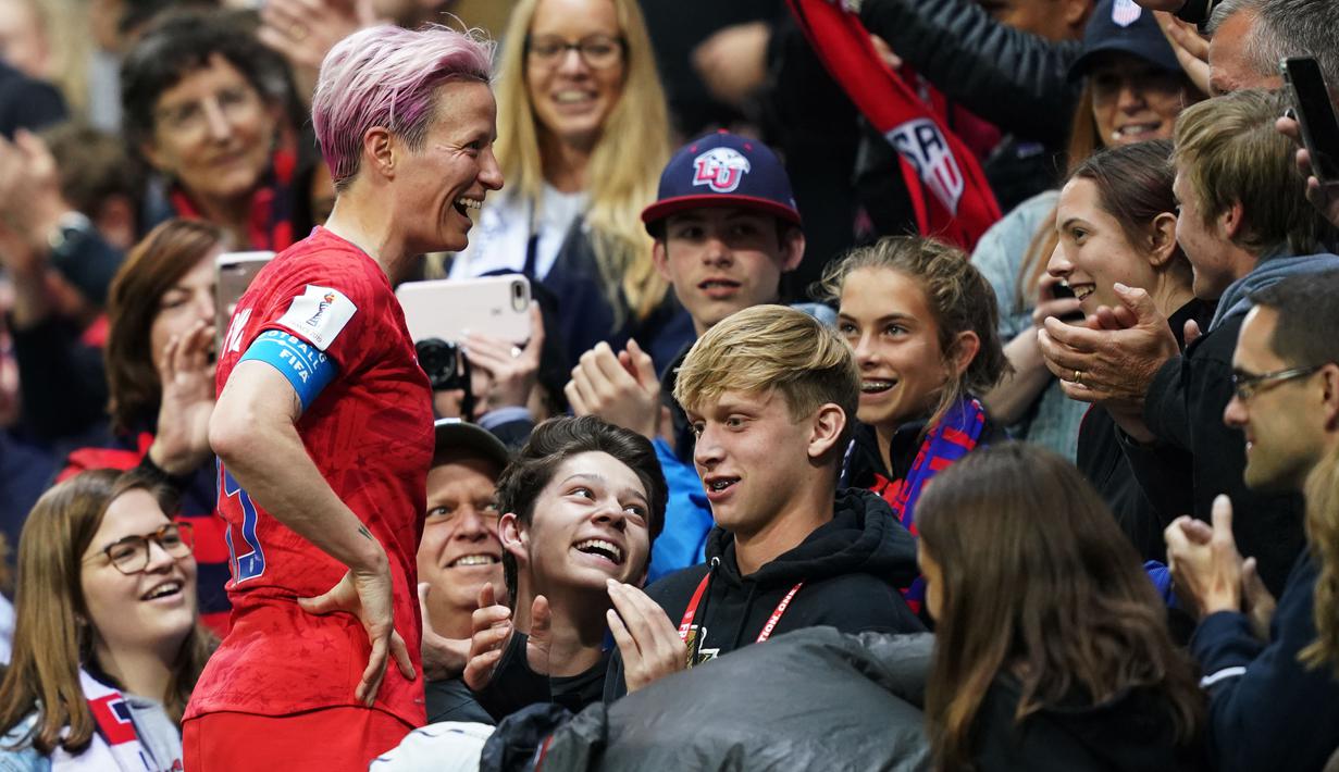 United States' forward Megan Rapinoe (L)  celebrates with supporters after winning  the France 2019 Women's World Cup Group F football match between USA and Thailand, on June 11, 2019, at the Auguste-Delaune Stadium in Reims, eastern France. (Photo by Lionel BONAVENTURE / AFP)